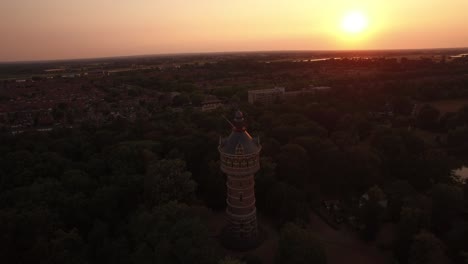 Una-órbita-Lenta-Alrededor-De-La-Torre-De-Agua-Mirando-Hacia-Atrás-Hacia-Una-Hermosa-Puesta-De-Sol