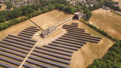 Eine-Kleine-Solarpanel-Farm-Überführung-Mit-Einem-Zug,-Der-Vom-Feld-Direkt-Neben-Dem-Gelände-Angetrieben-Wird