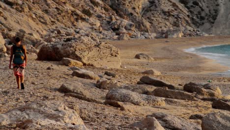 Girl-walking-on-the-pebbles-in-Platia-Ammos-beach-in-Kefalonia,-Greece