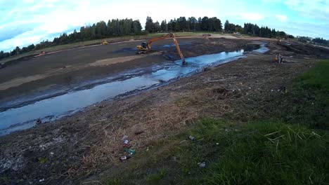 Yellow-Excavator-Works-with-Bucket-to-Clear-Mud-Sludge-and-Debris-from-the-Bottom-of-the-Drained-River