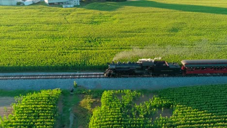 Tren-De-Vapor-Resoplando-En-La-Campiña-Amish-Visto-Por-Un-Dron