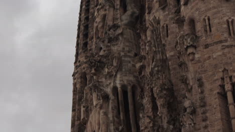 Old-side-of-La-Sagrada-Familia-pan-up-day-time,-overcast