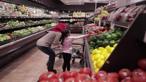 Mutter-Und-Tochter,-Die-Durch-Ein-Lebensmittelgeschäft-Gehen-Und-Rote-Paprika-Pflücken