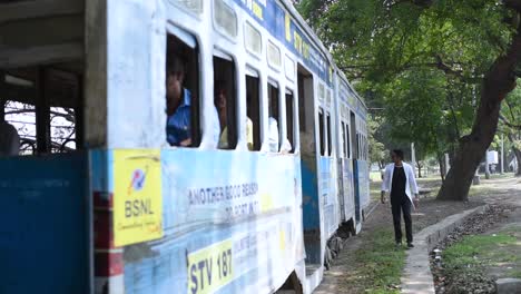 Tram-car-with-people-moves-from-very-close-to-a-young-male,-chance-of-accident