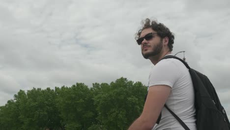 Shot-of-Guy-with-sunglasses,-Beard-and-curly-hair-sitting-down-in-Toulouse