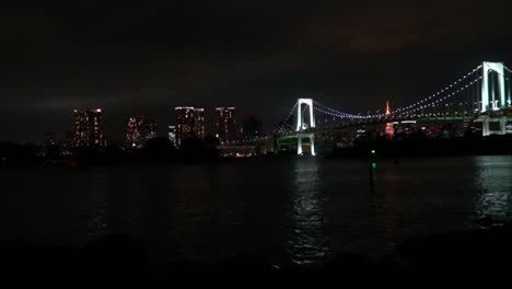 Timelapse,-La-Vista-Del-Puente-Del-Arco-Iris,-La-Torre-De-Tokio-Y-La-Reflexión-Sobre-El-Mar-Por-La-Noche