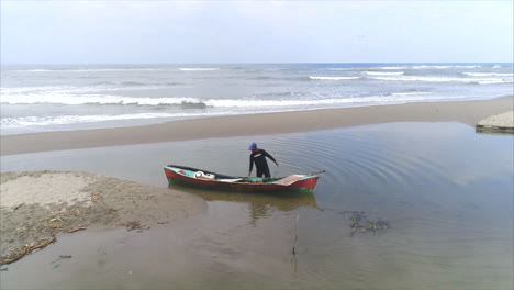 Antenne:-Honduranischer-Fischer,-Der-Einen-Fisch-Auf-Seinem-Kanu-Am-Strand-Setzt