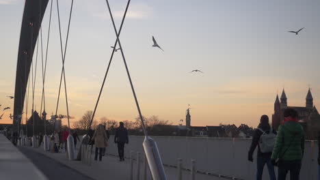 Gente-Caminando-En-Cámara-Lenta-A-Través-Del-Hoge-Brug,-Que-Es-Un-Puente-Para-Peatones-Y-Ciclistas-Que-Cruza-El-Mosa-En-Maastricht