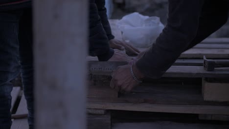 Refugiados-Afganos-Cortando-Palets-De-Madera-Para-Vivienda