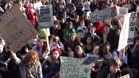 Uk-Februar-2019---Studenten,-Die-Bei-Einem-Sit-down-protest-Auf-Einer-Straße-Singen,-Halten-Plakate-Mit-Botschaften-über-Den-Klimawandel