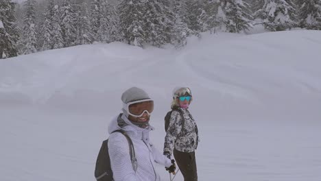 Slow-motion-shot-of-a-happy-couple-riding-on-skis-next-to-each-other-down-the-ski-slope-while-they-are-holding-hands