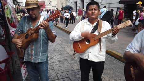 Zeigt-Mariachi-Musiker,-Die-Musik-Spielen-Und-Auf-Der-Straße-Singen,-Während-Menschen-Vorbeigehen