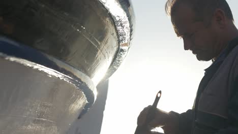 Pintor-Pinta-Molduras-De-Madera-De-Un-Barco-Pesquero-Griego-Hora-Dorada-Cinematográfica-De-ángulo-Bajo