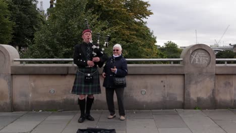 Anciana-Bailando-Junto-Al-Gaitero-Tocando-En-Edimburgo-Escocia-Para-Turistas