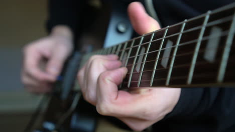 Hombre-Practicando-Una-Guitarra-Eléctrica-Negra-Vintage,-Ensayando-Acordes,-Solos-Y-Octavas-En-Un-Ambiente-De-Luz-Natural.