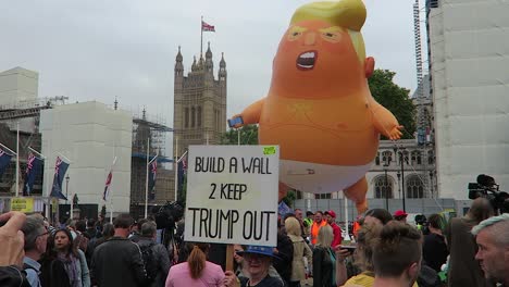 Manifestante-Adulta-Con-Pancarta-Contra-El-Presidente-Donald-Trump-Con-Globo-De-Triunfo-De-Bebé-En-El-Fondo-En-El-Jardín-De-La-Plaza-Del-Parlamento-El-4-De-Junio-De-2019