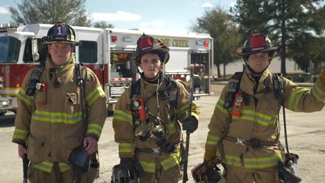 Group-of-firefighters-with-firefighting-equipment-stand-in-front-of-a-fire-rescue-truck