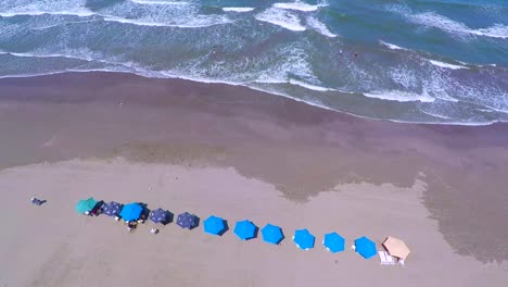 Bird´s-eye-view-of-the-coastline-Boca-del-Rio-beach,-image-from-the-heights-of-how-the-beach-looks,-with-serene-waves-and-white-sand,-the-umbrellas-accompany-the-coming-and-going-of-the-sea