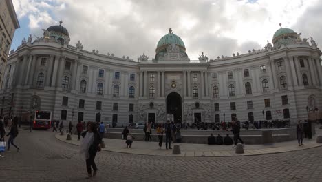 The-Hofburg-Palace,-Vienna,-on-a-partly-cloudy-afternoon-with-tourists-in-front