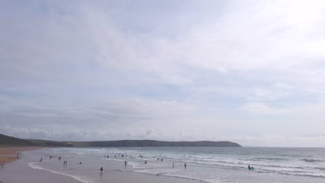 Turistas-Bañándose-Al-Sol-En-Una-Playa-De-Arena-En-Verano,-Desapareciendo-Del-Cielo