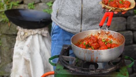 A-slow-motion-shot-of-a-street-vendor-serving-Chilly-Chicken-in-a-bio-degradable-plate-in-the-streets-of-Darjeeling