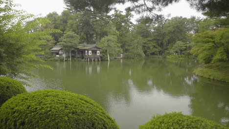 Vista-Natural-Del-Estanque-Kasumi-En-El-Jardín-Kenroku-en-Con-Una-Casa-De-Té-Al-Fondo