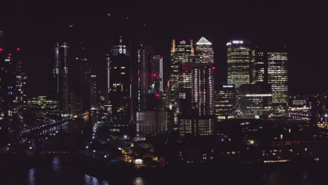 Aerial-View-of-London-Financial-District-at-night-from-the-river-Thames