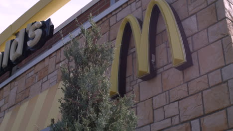 Tiro-Giratorio-Estabilizado-Del-Logotipo-De-Mcdonald&#39;s-Y-Carteles-De-Marca-En-El-Exterior-Del-Edificio-De-Un-Restaurante