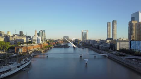 Aerial-shot-of-Woman’s-Bridge-and-Sarmiento-Frigate-in-Puerto-Madero,-Buenos-Aires