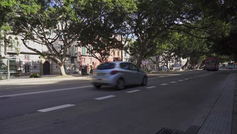 Bright-red-tourist-bus-cruises-down-the-main-street-in-Malaga-on-a-quiet-day