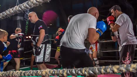 Kickboxers-Dando-Vueltas-Alrededor-Del-Anillo-De-Cuerda,-Lanzando-Puñetazos-En-El-Aire---Ejercicios-De-Rutina,-Video-En-Cámara-Lenta,-Cámara-Siguiendo-La-Acción