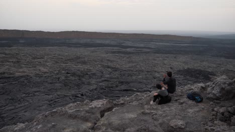 Steady-shot-of-a-man-and-a-woman-taking-videos-of-themselves,-showing-the-beauty-of-dallol-volcano-as-their-background