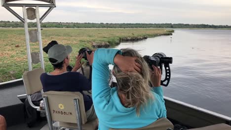 Los-Huéspedes-Del-Safari-Fotográfico-Fotografían-Aves-A-Lo-Largo-Del-Río-Chobe,-áfrica