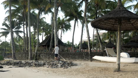 Mauritischer-Einheimischer-Fischer,-Der-Mit-Rute-Und-Leine-Am-Strand-Entlang-Spaziert,-Pan-Shot