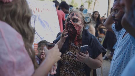 Nahaufnahme-Eines-Maskenbildners-Im-Stil,-Der-Prothetik-Vor-Halloween-Anwendet-Spaziergang-Der-Zombies-Am-Tag-Der-Toten-In-Der-Copacabana-Unter-Der-Menge