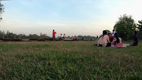 Tiro-De-Lapso-De-Tiempo-Exterior-Medio-De-Picnic-Familiar-En-El-Césped-Con-Vendedores-Y-Otras-Personas-Caminando-Durante-El-Día-Por-Angkor-Wat