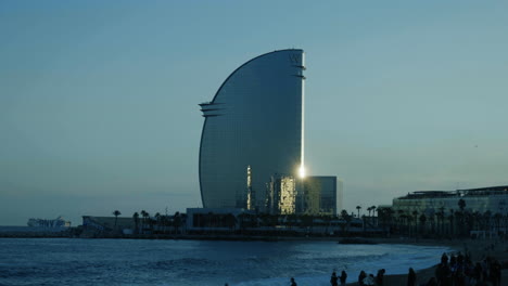 Barceloneta-Strand-Einer-Der-Beliebtesten-In-Der-Stadt-Bei-Sonnenuntergang-Und-Hotel-Vela-In-Barcelona,-Spanien