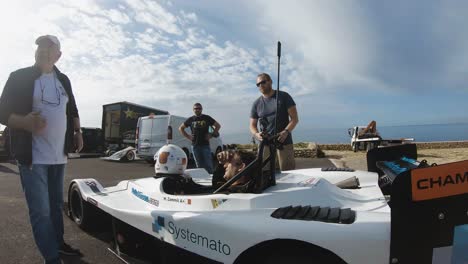 Racing-Car-Driver-Talking-With-A-Man-At-The-Hill-In-Imtahleb-Malta-Under-The-Heat-Of-The-Sun---Closeup-GoPro-Shot