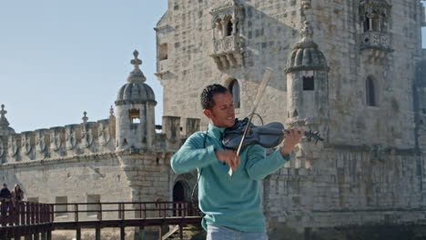 Lächelnder-Straßengeiger,-Der-Musik-In-La-Torre-De-Belem-In-Lissabon,-Portugal-Spielt