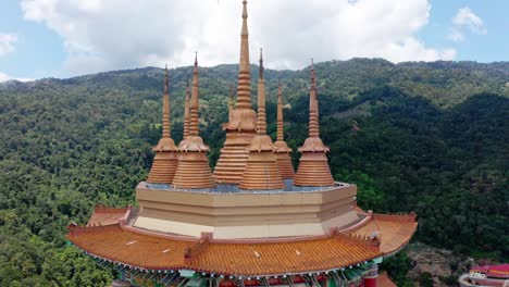 Kek-Lok-Si-Buddhist-temple-with-Kuan-Yin-Statue-Pavilion-building-roof-detail-on-a-sunny-day,-Aerial-drone-spiral-down-reveal-shot