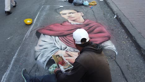 Toma-Estática-De-Un-Artista-Callejero-Dibujando-Un-Pastel-De-Frida-Kahlo-En-Bogota-Colombia