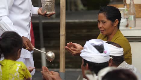 Balinese-followers-of-Hinduism-receive-holy-water-from-priest-poured-into-cupped-hands-and-take-a-sip