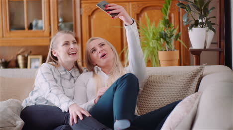 Zwei-Positive,-Energische-Frauen,-Die-Ein-Selfie-Foto-Auf-Einem-Sofa-Im-Luxuriösen-Modernen-Wohnzimmer-Machen-5