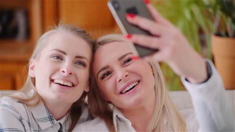 Two-Positive-Energetic-Women-Taking-Selfie-Photo-On-A-Sofa-In-Luxury-Modern-Living-Room-6