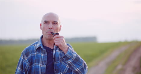 Contented-Bald-Farmer-Smoking-His-Pipe-On-Field