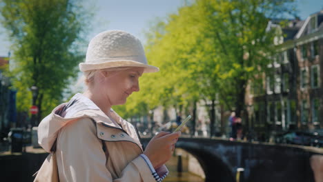 Woman-Uses-Phone-Near-Amsterdam-Canal