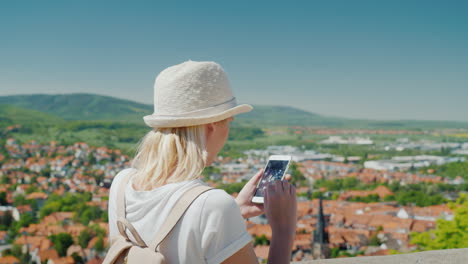 Tourist-With-Smartphone-Above-German-Town