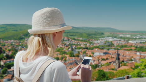 Tourist-With-Smartphone-in-Front-of-German-Town