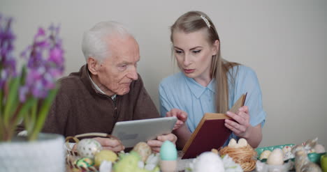 Junge-Frau-Mit-Großvater-Auf-Digitalem-Tablet-Im-Internet-Surfen-3
