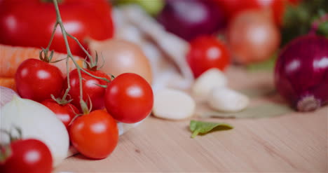 Close-Up-Of-Various-Vegetables-On-Table-Rotating-Fresh-Cherry-Tomatos-Carrot-Red-Onion-And-Garlic-1
